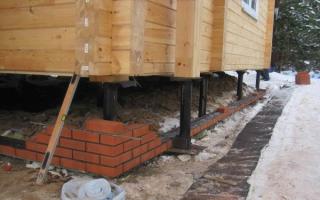 Aislamiento de los cimientos de pilotes de una casa de madera Acabado y aislamiento del sótano de los cimientos sobre pilotes.